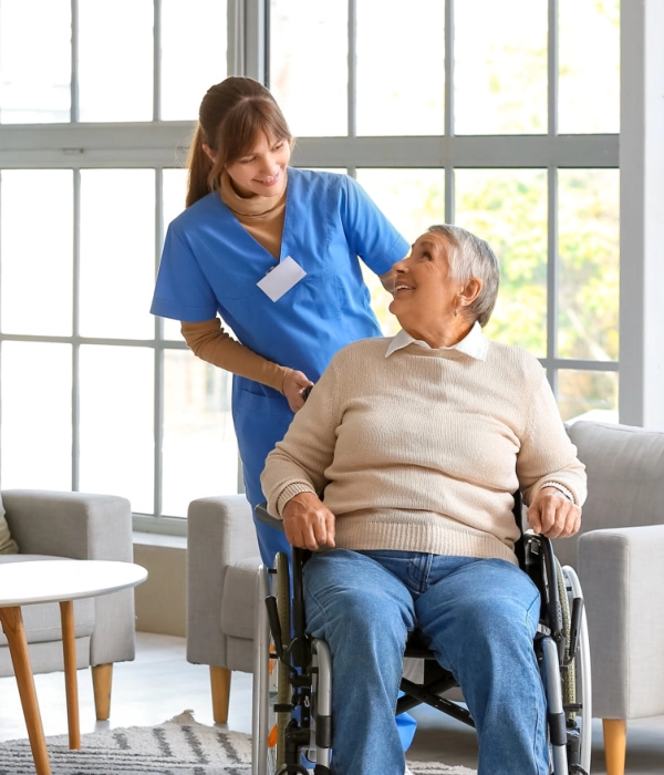 A female caregiver and a senior woman sitting on a wheelchair