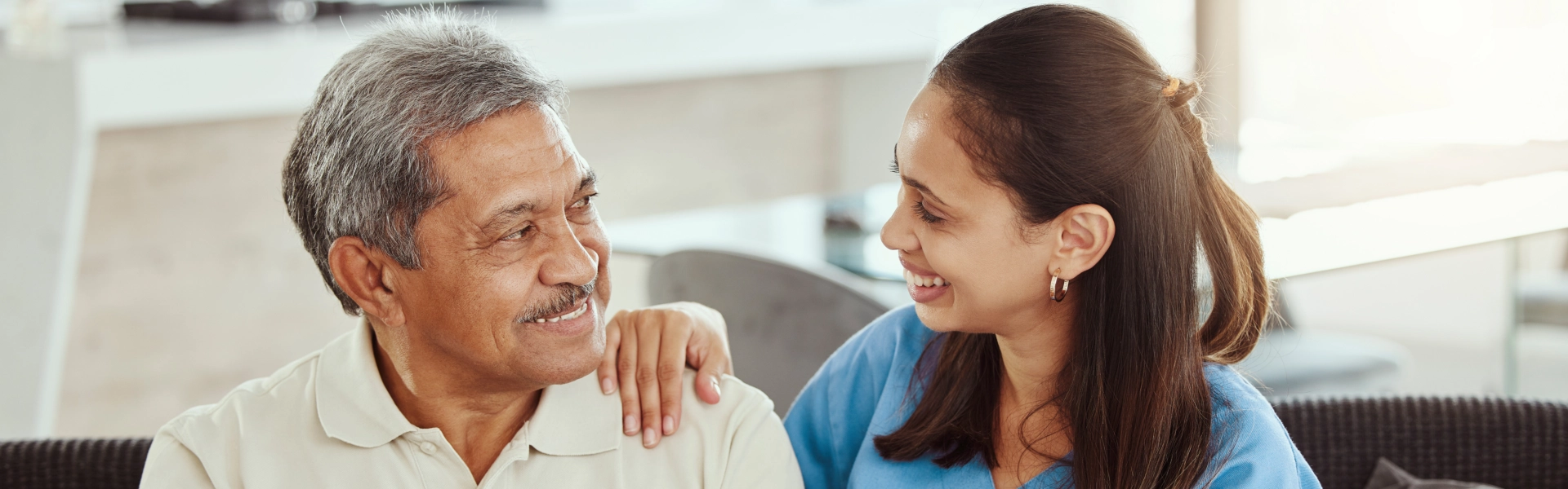 A senior man and female caregiver looking at each other