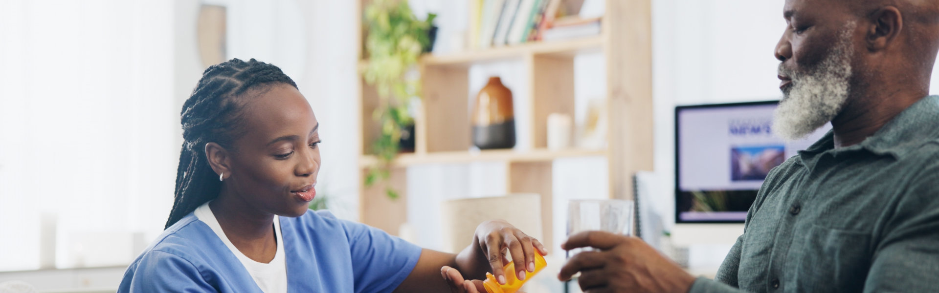 caregiver giving medicine to the old man